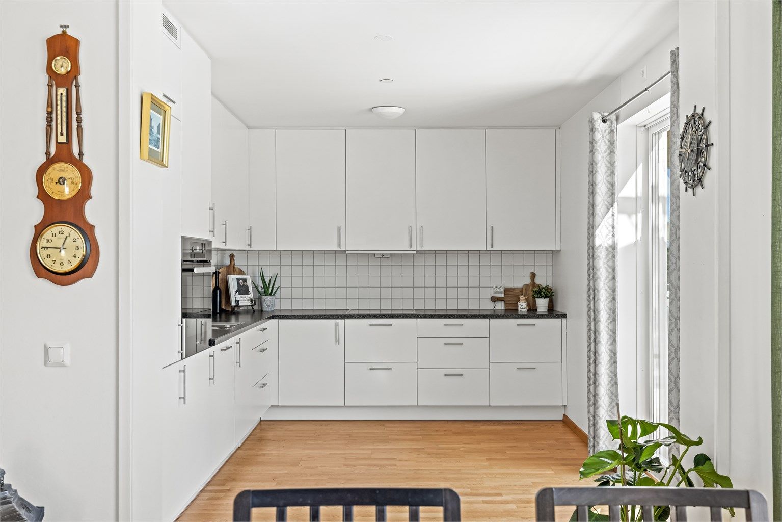 Kjøkkeninnredning fra byggeåret med glatte fronter og laminert benkeplate. Det er godt med skap- og benkeplass.