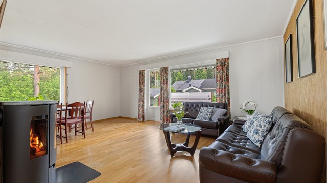 Stuen oppleves som lys og det er fin plass til både sofakrok og spisestuebord. Det er montert en stilig peisovn som gir lun varme til hele etasjen
