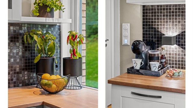 Gjennomførte materialvalg med benkeplate i tre og mørke mosaikkfliser.