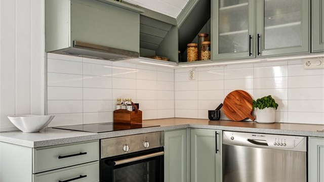 Detalj av kjøkkeninnredningen med profilerte fronter og moderne håndtak.