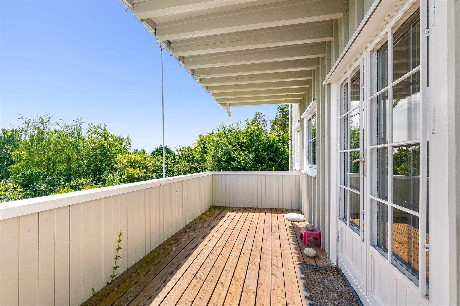 Sydøstvendt balkong på 11 m² med terrassebord og rekkverk i tre.