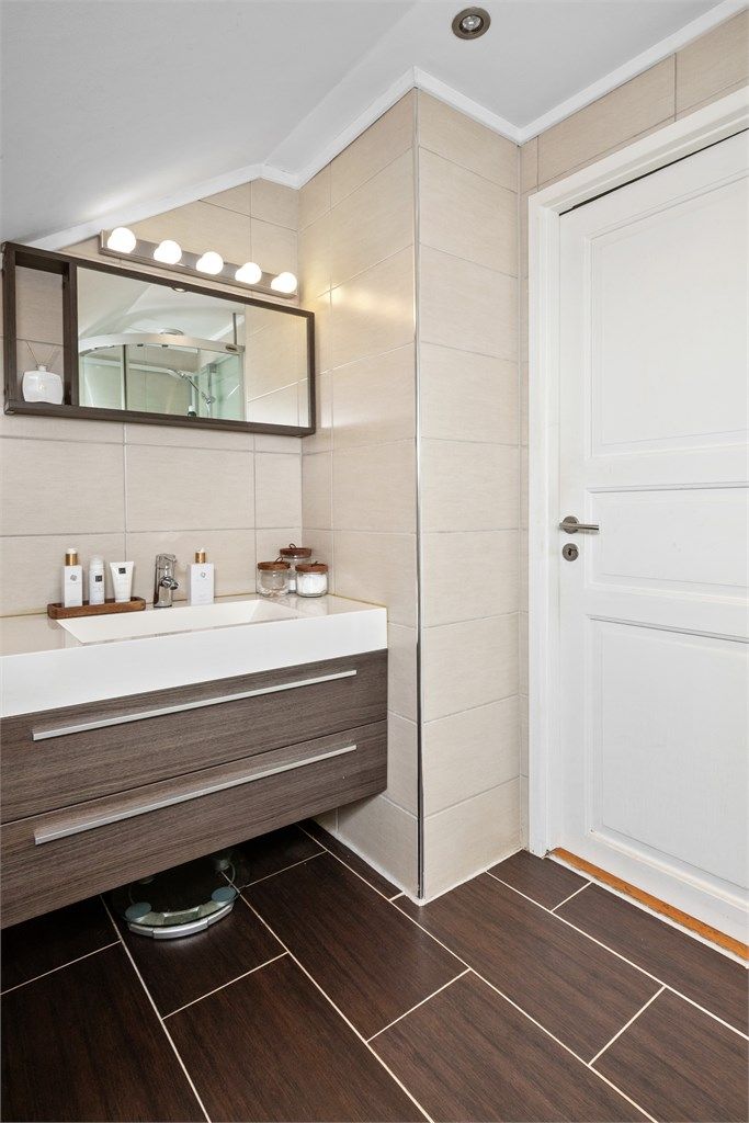  Badet i loftsetasjen ble oppgradert i 2010 og fremstår som delikat med beige veggfliser, brune gulvfliser, gulvvarme og hvitmalt himling med downlights. 