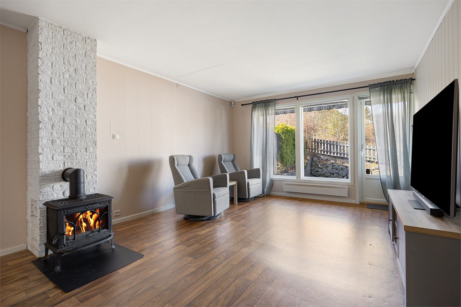 En peisovn med glassdør fra byggeåret gir både effektiv varme og en hyggelig atmosfære.