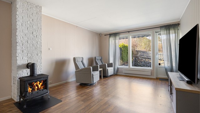 En peisovn med glassdør fra byggeåret gir både effektiv varme og en hyggelig atmosfære.