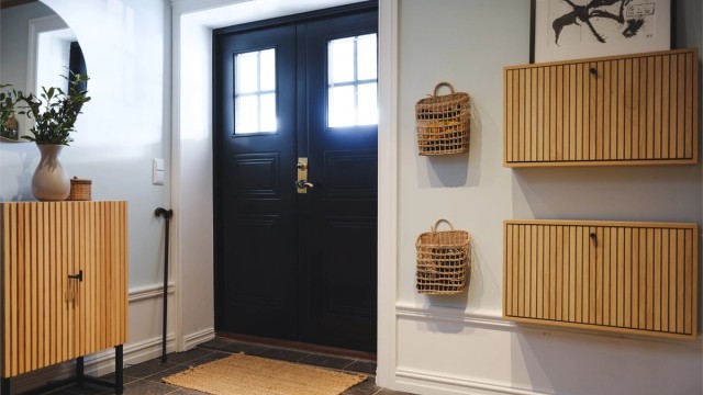 Hallen har et innbydende preg med flislagt gulv med gulvvarme og en moderne spilevegg.