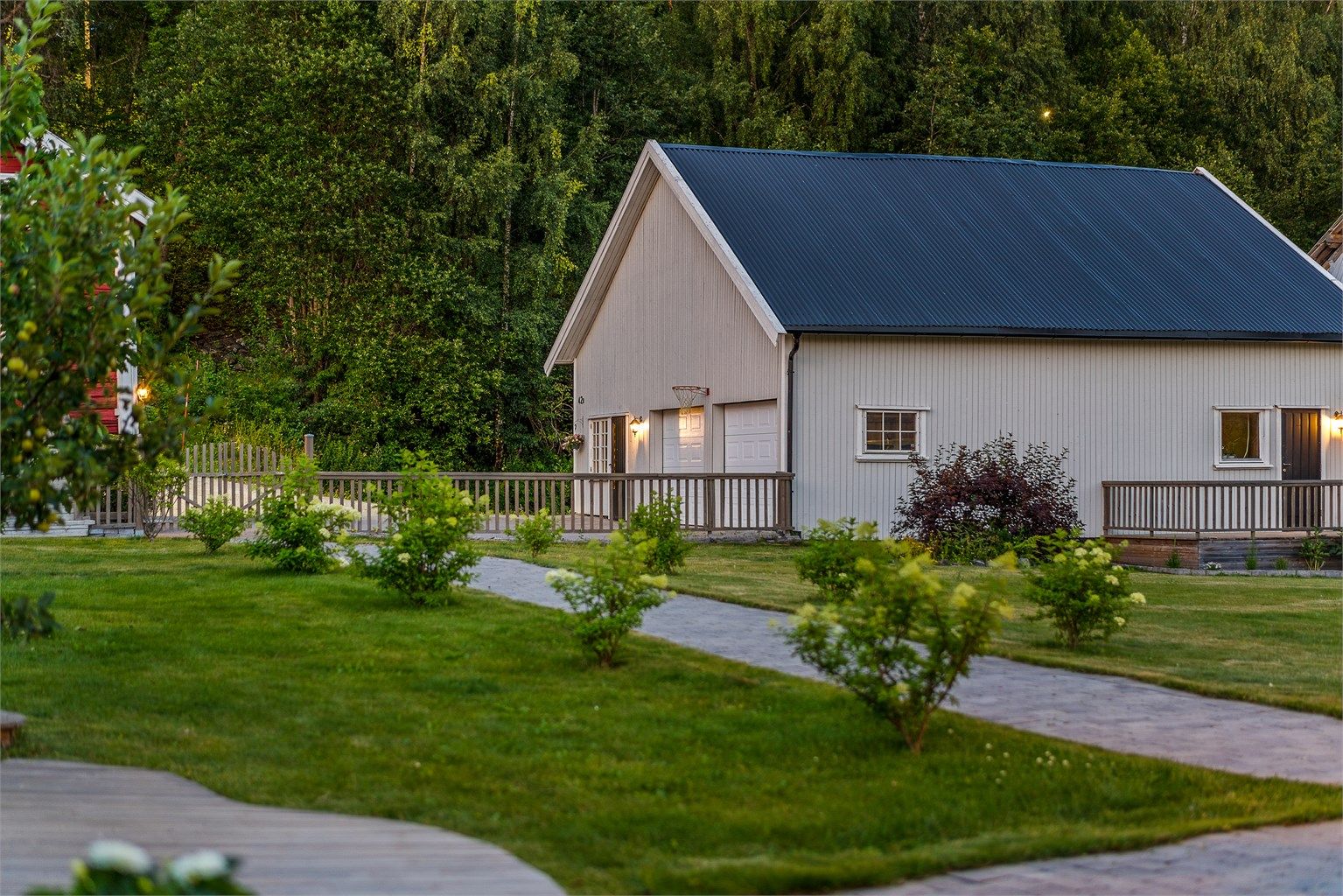 Man ønskes velkommen av steinlagt gangvei med flott beplantning inn til boligen