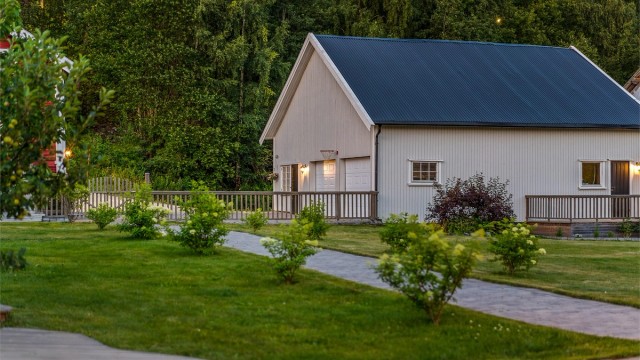 Man ønskes velkommen av steinlagt gangvei med flott beplantning inn til boligen