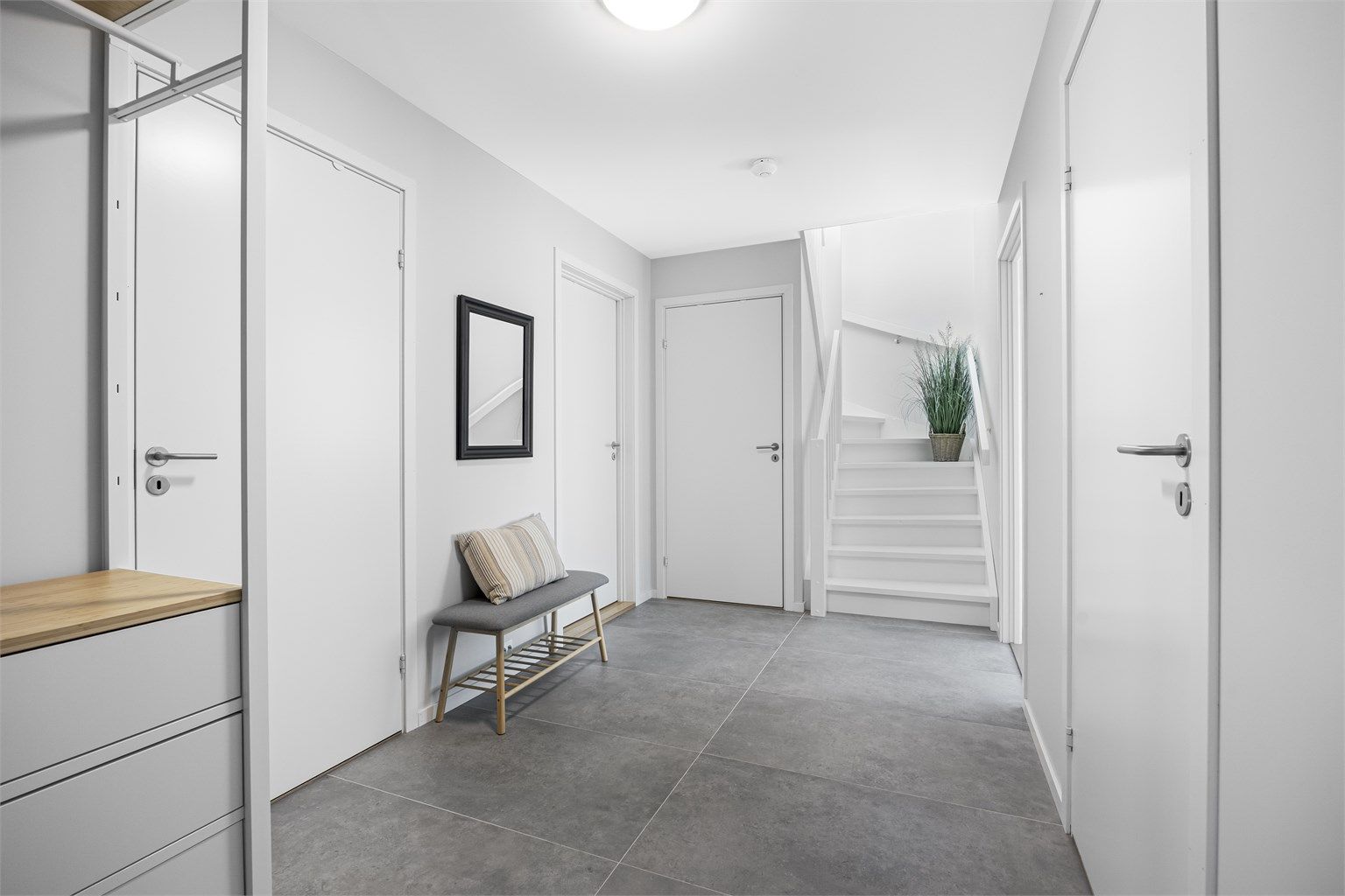 Romslig entré med plass til garderobe og varmekabler i gulv.