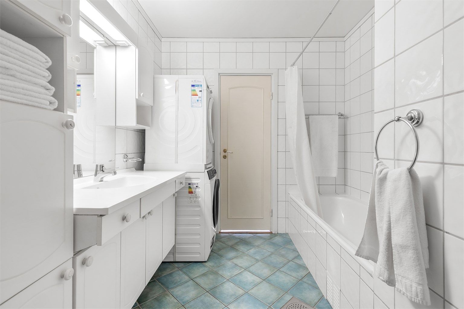 Badet er innredet med vegghengt servantinnredning med ovenpåliggende servant og armatur, samt speil, belysning med stikkontakt og skap på vegg over servant. Det er opplegg for vaskemaskin, gulvstående toalett og innebygd badekar med dusjforheng.