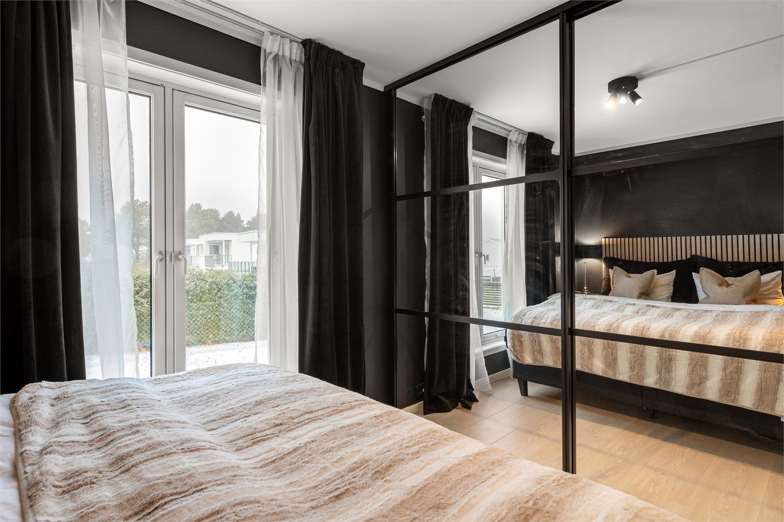 Rommet er utstyrt med en romslig skyvedørsgarderobe med speilfronter og god innredning.