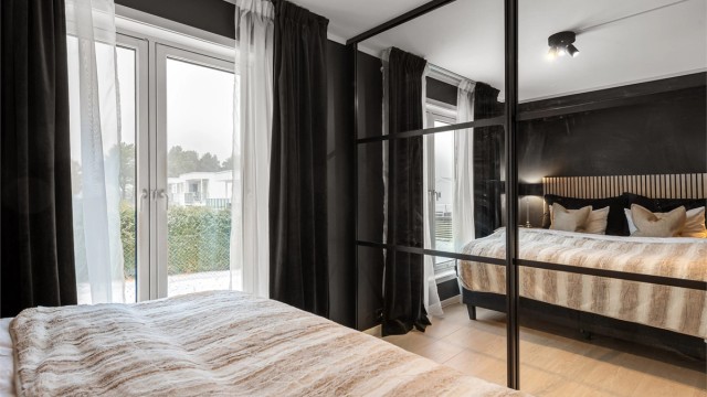 Rommet er utstyrt med en romslig skyvedørsgarderobe med speilfronter og god innredning.