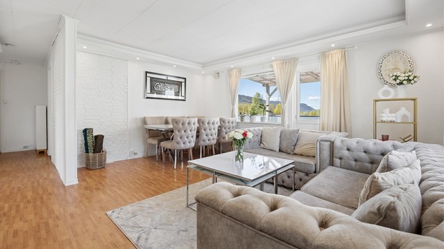 Lys stue med plass til sofagruppe og spisebord.