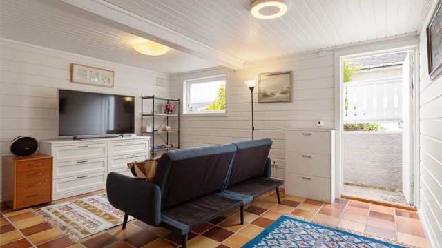 TV-stuen har flislagt gulv med elektrisk gulvvarme, som gir god komfort på kjøligere dager. Rommet har også eksisterende opplegg for vann og avløp, noe som gir fleksible muligheter for fremtidig bruk, forutsatt nødvendige godkjenninger.