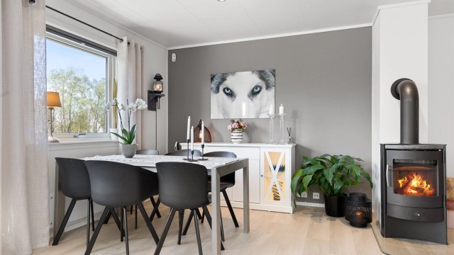 Her er det god plass til en egen spisesone i tilknytning til stuen, sentralt plassert ved peisovnen.