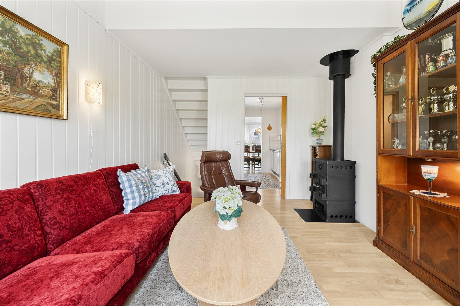 Vegger med malte panelplater og laminat på gulvet gir et lyst og helhetlig inntrykk i oppholdsrommene.