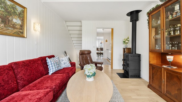 Vegger med malte panelplater og laminat på gulvet gir et lyst og helhetlig inntrykk i oppholdsrommene.
