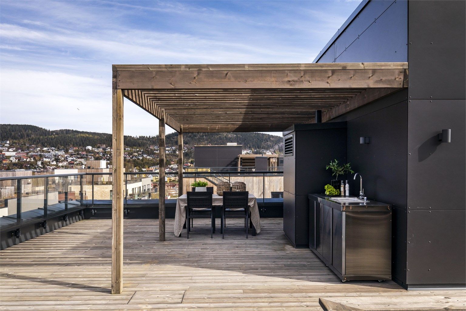 Takterrassen byr på mer enn bare stort areal med mye boltreplass og flott utsikt, men også en pergola og utekjøkken med innlagt vann