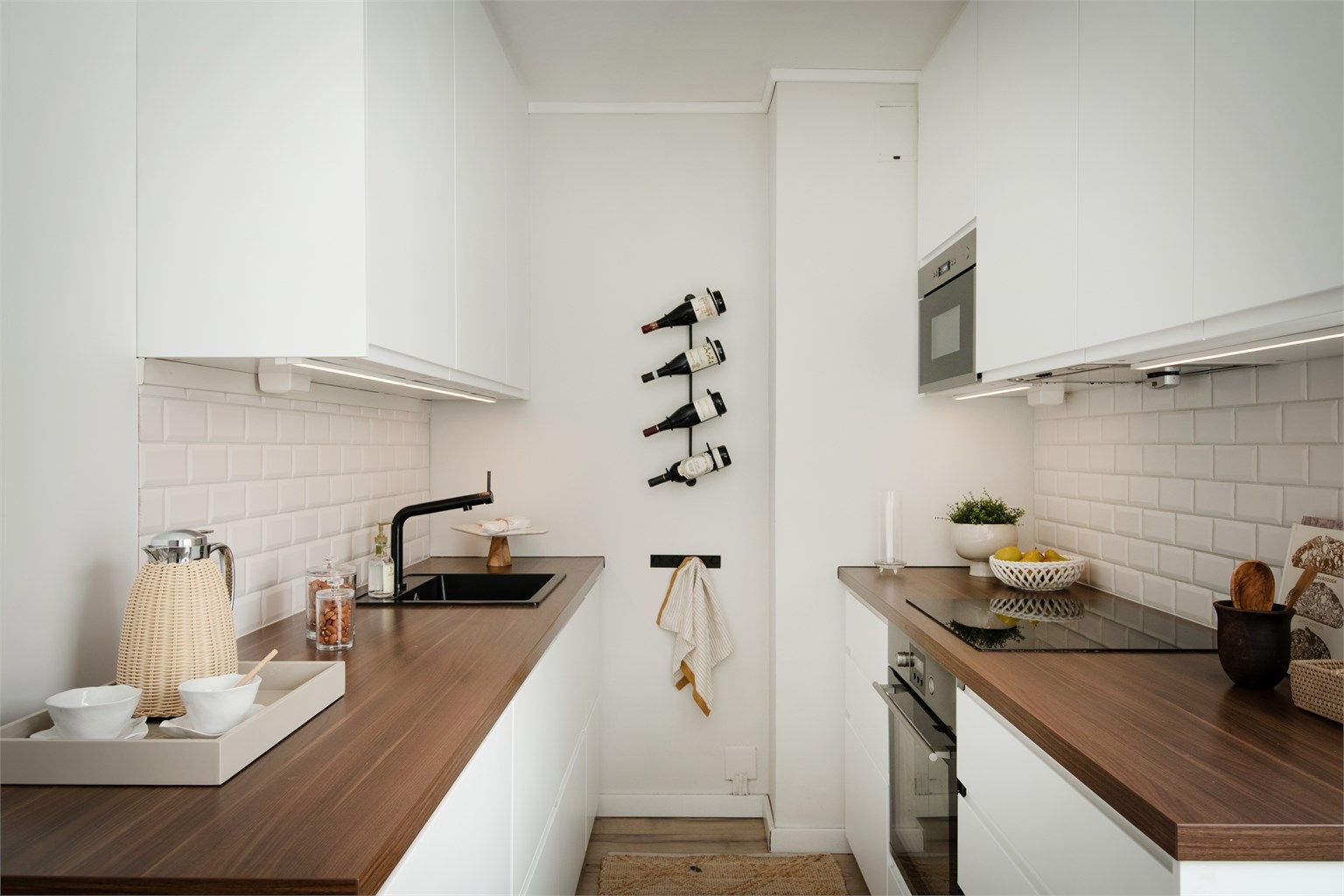 Kjøkkeninnredningen har moderne, glatte fronter og benkeplate av laminat med nedsenket vask. 