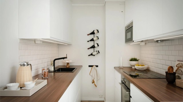 Kjøkkeninnredningen har moderne, glatte fronter og benkeplate av laminat med nedsenket vask.