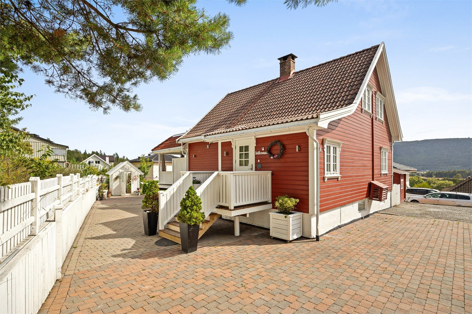 Parkering på egen gårdsplass, som er asfaltert og belagt med belegningsstein.