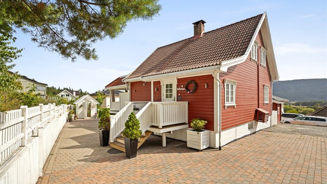 Parkering på egen gårdsplass, som er asfaltert og belagt med belegningsstein.
