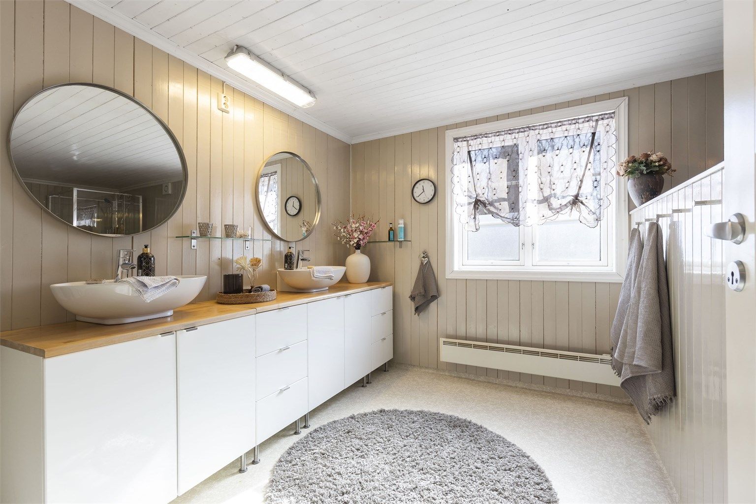 Baderommet i hovedboligen er innredet med servantinnredning med to servanter, speil, badekar og dusjkabinett.