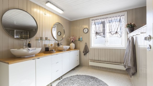 Baderommet i hovedboligen er innredet med servantinnredning med to servanter, speil, badekar og dusjkabinett.