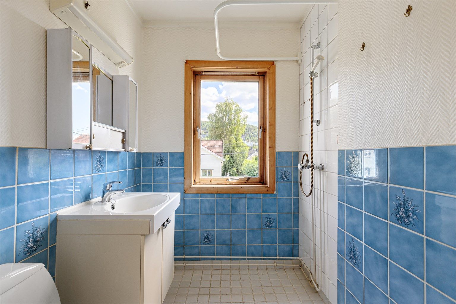 Baderommet er innredet med gulvstående toalett, servantmøblement og dusjsone. Det gjøres oppmerksom på at badet har i sin helhet fått tilstandsgrad 3 iht. tilstandsrapporten, og det må forventes at badet må pusses opp