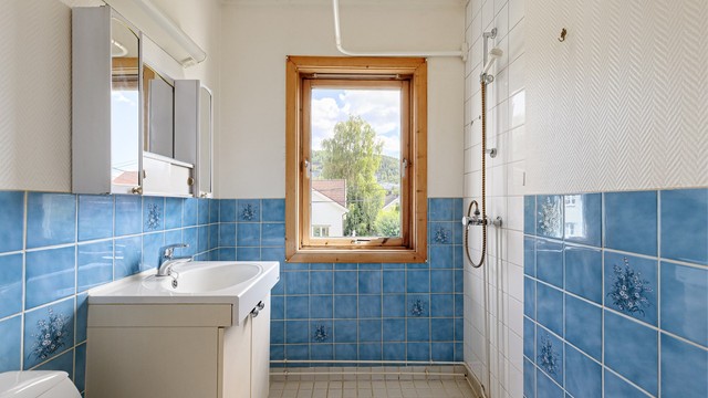 Baderommet er innredet med gulvstående toalett, servantmøblement og dusjsone. Det gjøres oppmerksom på at badet har i sin helhet fått tilstandsgrad 3 iht. tilstandsrapporten, og det må forventes at badet må pusses opp