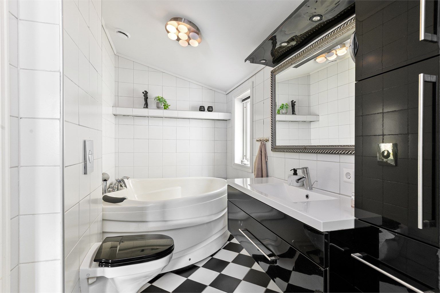 Badet i første etasje har flislagt gulv med gulvvarme, og er utstyrt med både badekar og dusjnisje.