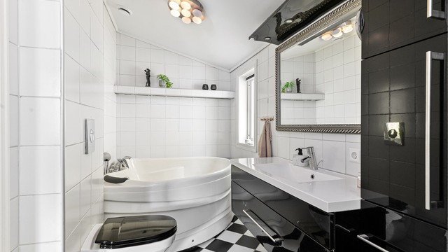 Badet i første etasje har flislagt gulv med gulvvarme, og er utstyrt med både badekar og dusjnisje.