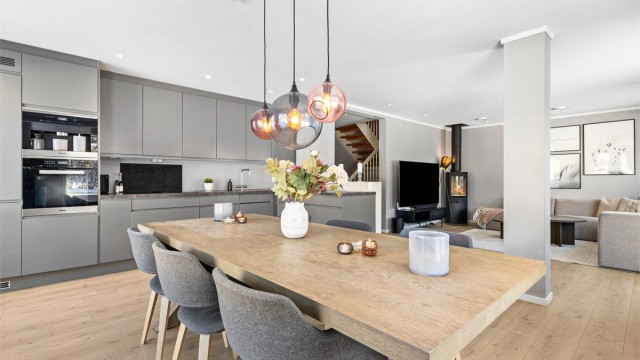 Den åpne løsningen mellom stue og kjøkken skaper en sosial atmosfære når man er med venner eller familie.