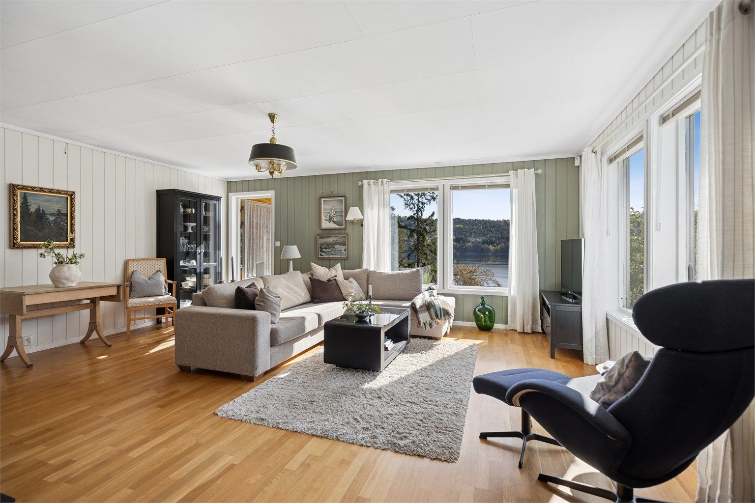 Lys og innbydende stue med store vindusflater som slipper inn rikelig med naturlig lys.