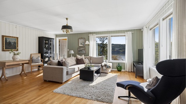 Lys og innbydende stue med store vindusflater som slipper inn rikelig med naturlig lys.