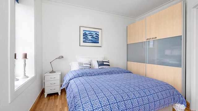 Rommet er innredet med en romslig skyvedørsgarderobe.