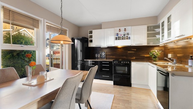 Pent kjøkken med profilerte fronter på skap og skuffer, og benkeplate av laminat med nedfelt kjøkkenvask