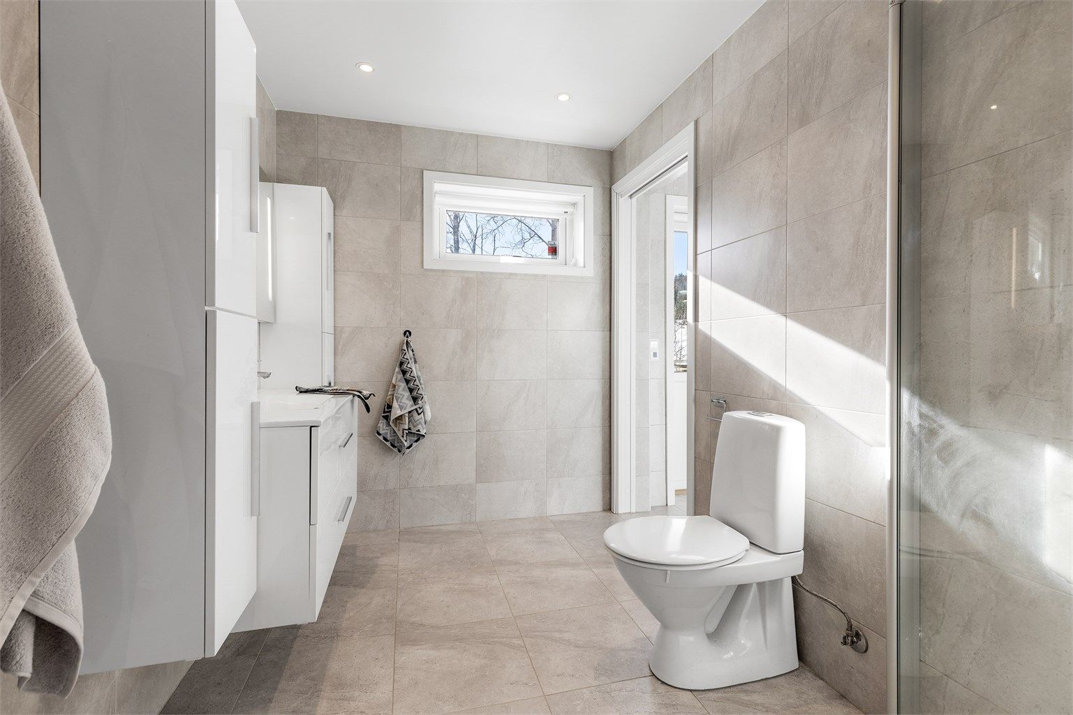 Lyst og moderne bad i 1. etasje med downlights i tak samt varmekabler i gulv