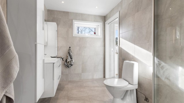 Lyst og moderne bad i 1. etasje med downlights i tak samt varmekabler i gulv