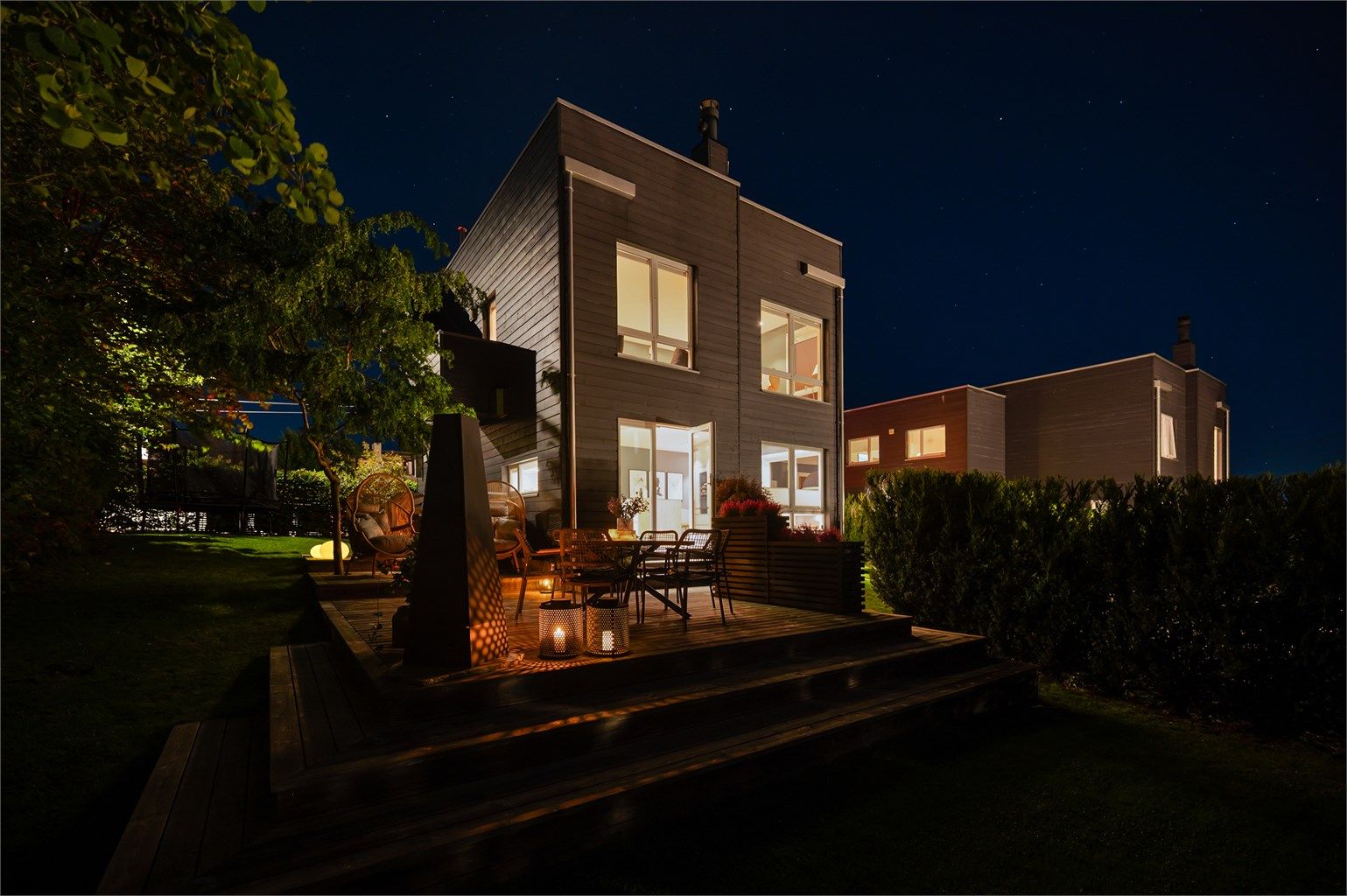 Huset sett fra hagen på kveldstid.