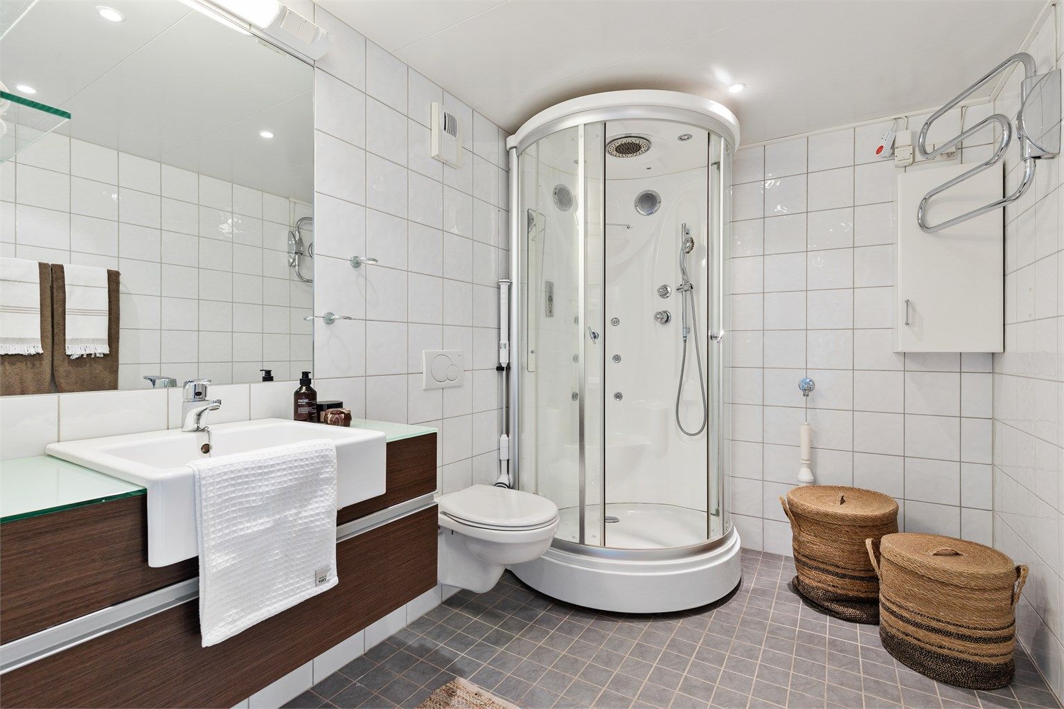 Dusjkabinett med dusjarmatur. Vegghengt toalett. Mekanisk avtrekk med ventil i vegg. Opplegg for vaskemaskin.