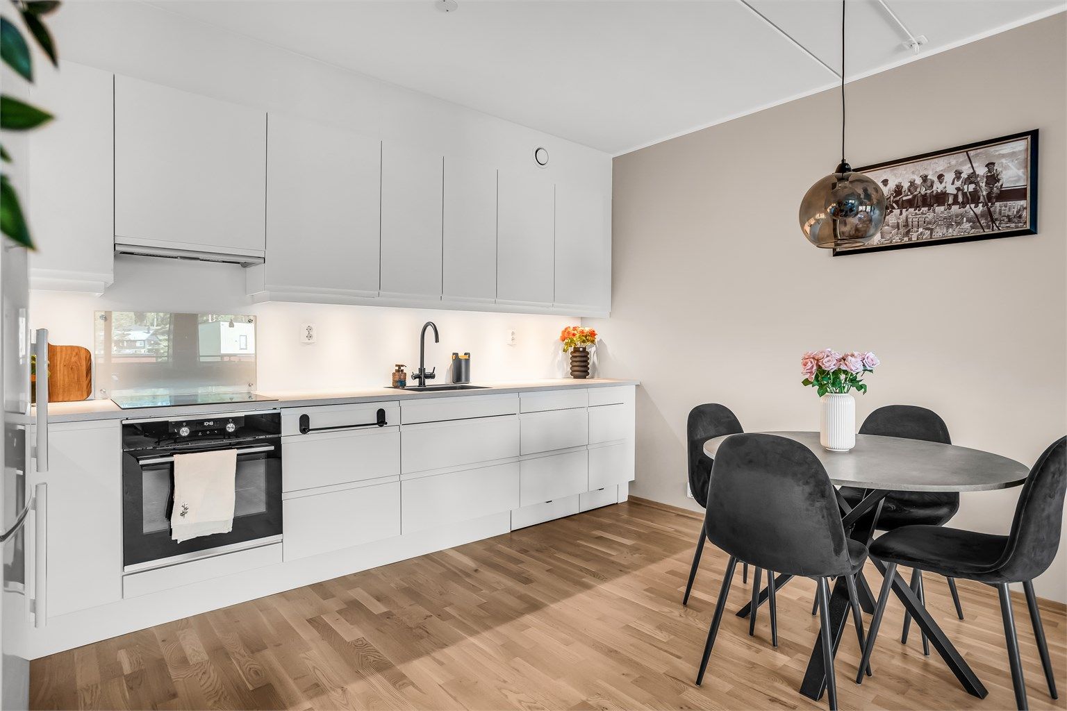 Kjøkkeninnredning fra Norema med glatte fronter og laminatbenkeplate.