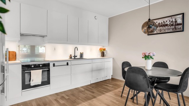 Kjøkkeninnredning fra Norema med glatte fronter og laminatbenkeplate.