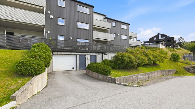 Fra Gåsebyveien er det enkel innkjøring til blokkens garasjekjeller, heis opp til leilighetens etasjeplan