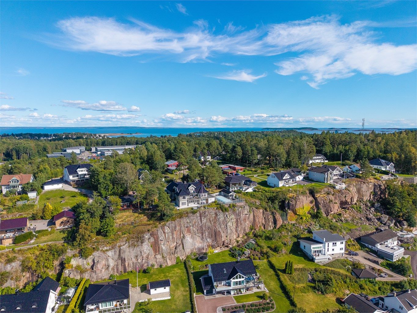 Tomten er omgitt av trær som skaper både skjerming og en naturlig ramme rundt eiendommen.
