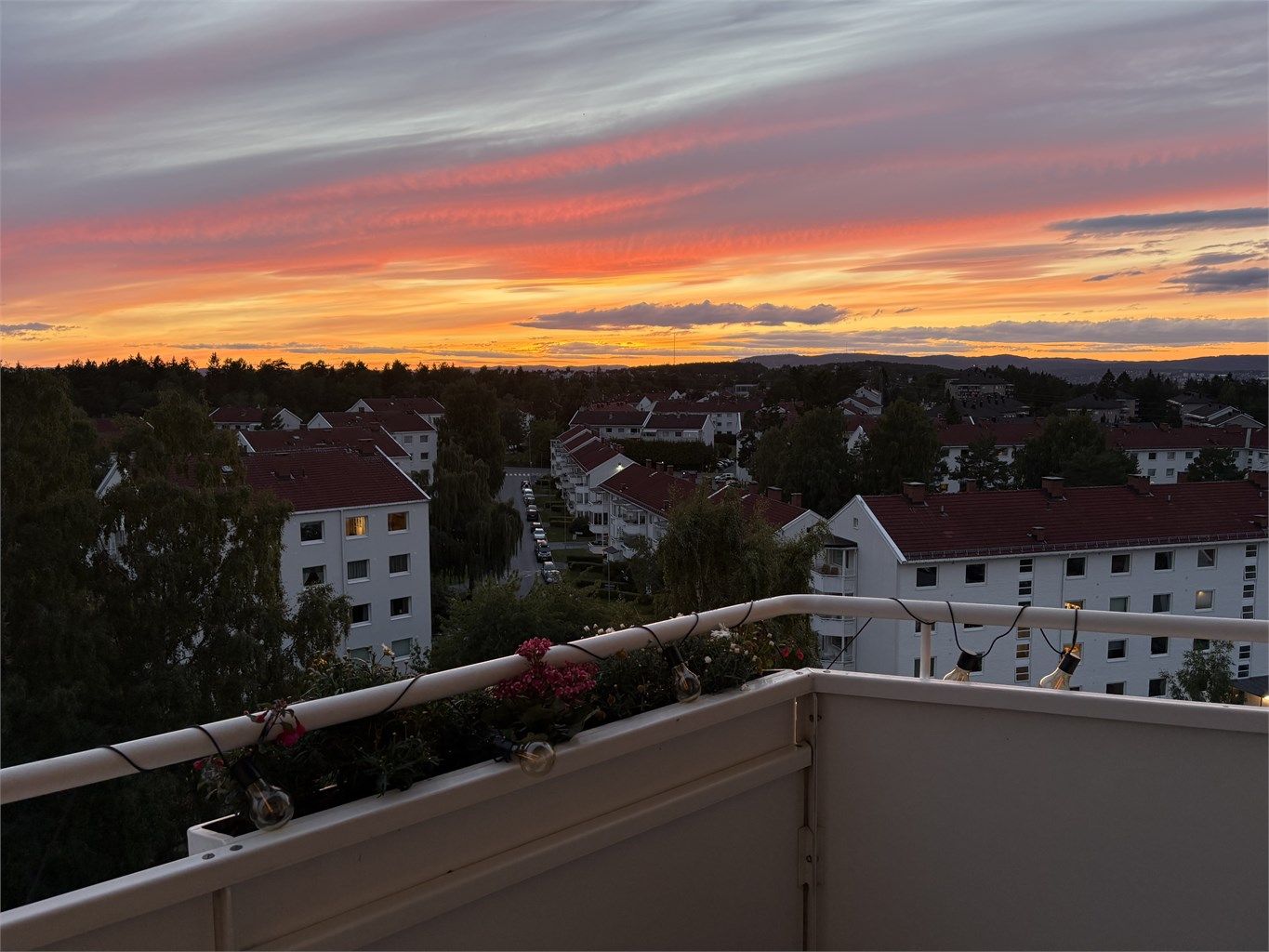 Magiske kveldsfarger over nærområdet sett fra leiligheten (selgers bilde).