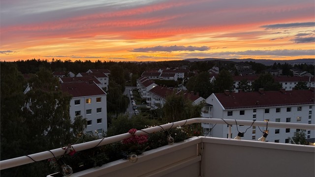 Magiske kveldsfarger over nærområdet sett fra leiligheten (selgers bilde).