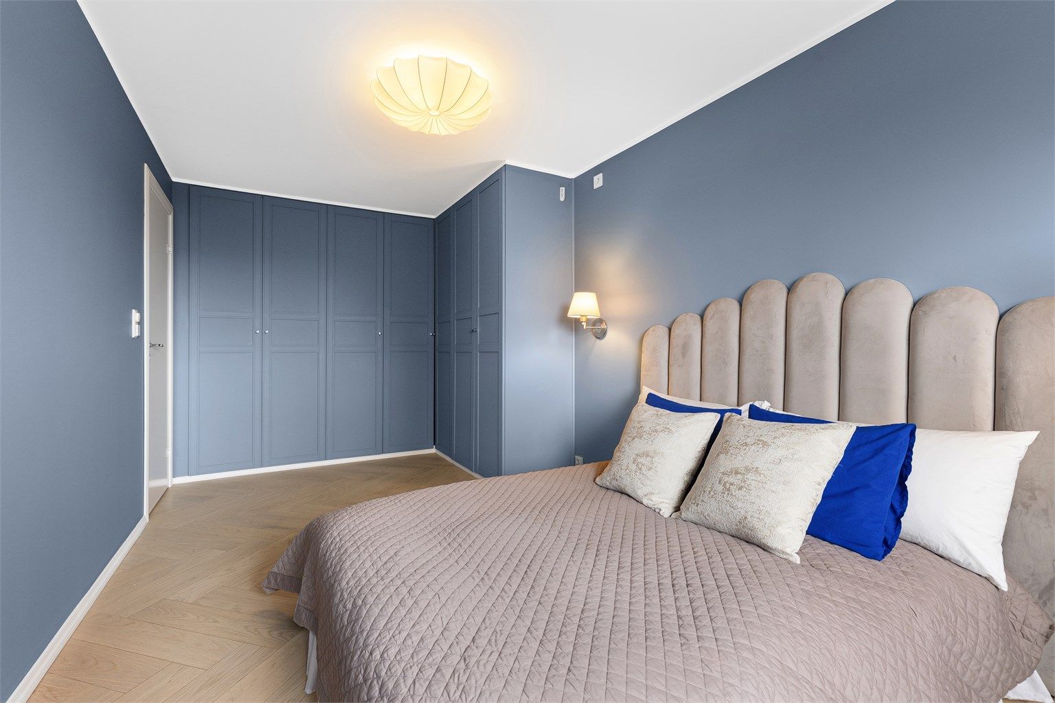 De plassbygde garderobeskapene gir rikelig med oppbevaringsplass og utnytter rommets fulle takhøyde.