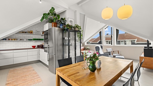 Den åpne planløsningen skaper en sosial og luftig sone mellom stue, spisestue og kjøkken.