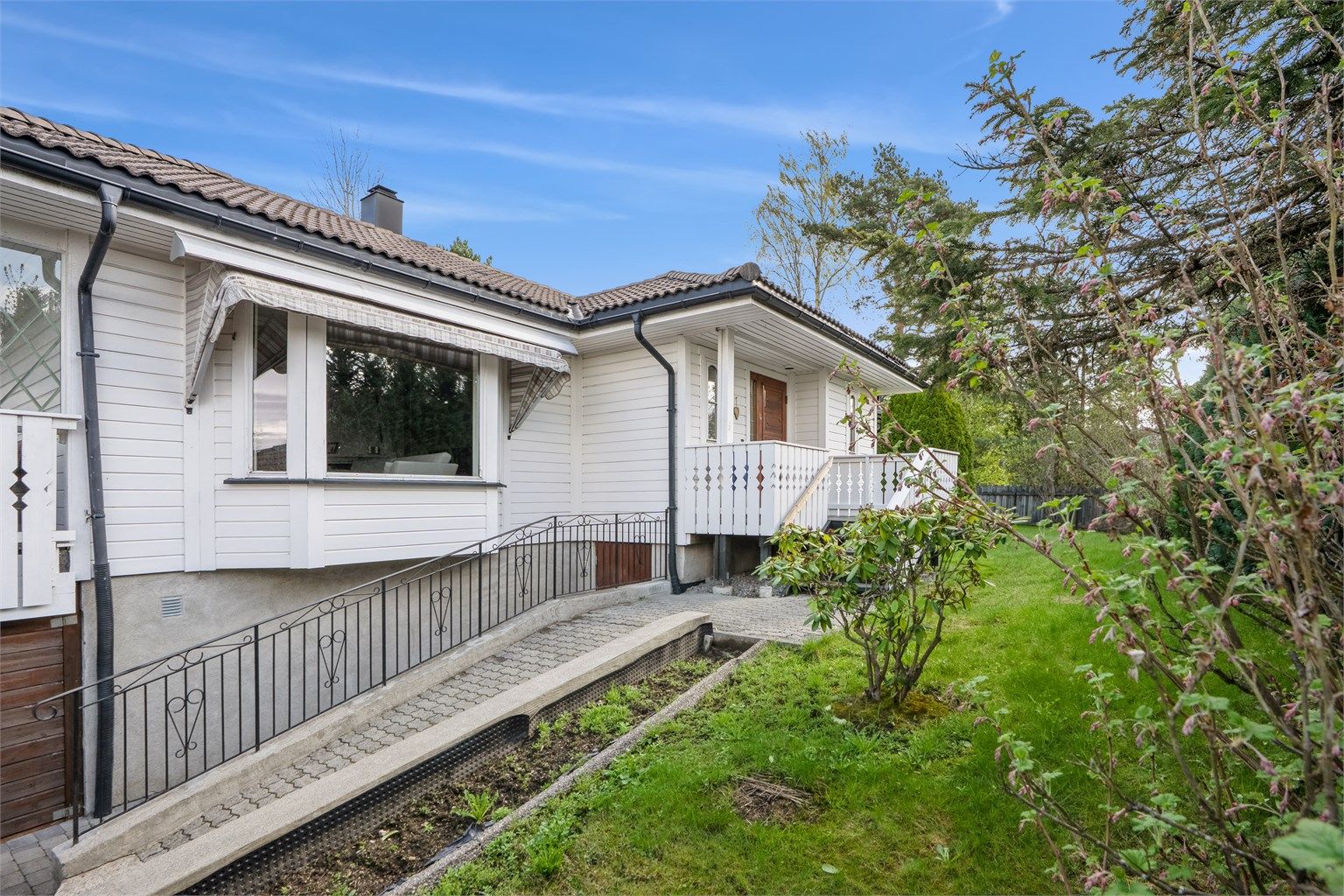 Eiendommen er pent opparbeidet med belegningsten, gressplen, hekk og beplantning. 