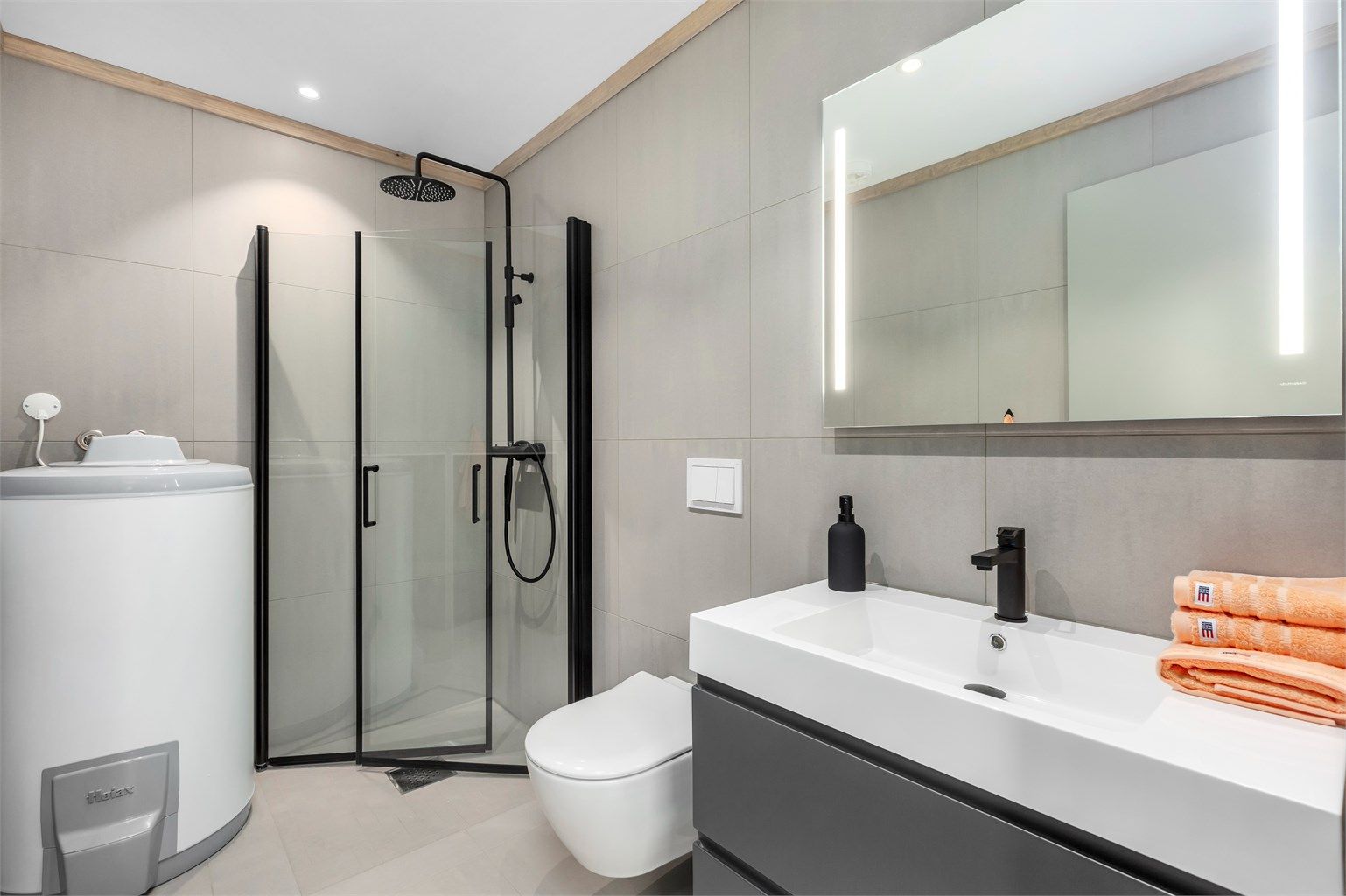 Badet har samme gulvfliser som i gangen og store rektangulære fliser på veggene.